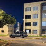 Cena de crime em rua residencial no Guará II, DF, com viaturas policiais e fita de isolamento, representando homicídio.