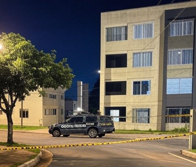 Cena de crime em rua residencial no Guará II, DF, com viaturas policiais e fita de isolamento, representando homicídio.