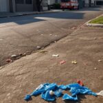 Rua em Vicente Pires com viatura de ambulância e embalagens de chiclete no chão, representando incidente de agressão.