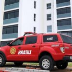 Prédio residencial em Águas Claras com viatura dos bombeiros em cena de socorro após queda de janela.