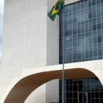 Edifício do Tribunal de Justiça em Brasília com bandeira a meio mastro em sinal de luto pela morte de desembargador.
