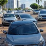 Cena de acidente com capotamento de carro Onix em rua de Águas Claras, Brasília, com veículos danificados e detritos no asfalto.
