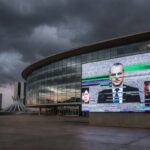 Edifício da CLDF em Brasília com tela de transmissão ao vivo com falhas, representando ineficiência e frustração dos cidadãos do DF.
