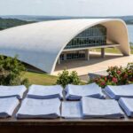 Mesa com pilhas de documentos e relógio em escritório público de Brasília, representando burocracia e prazos apertados para inscrições no conselho da Caesb.