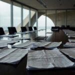Documentos financeiros em mesa de reunião na CLDF, pressionando BRB por transparência em meio a suspeitas de irregularidades.