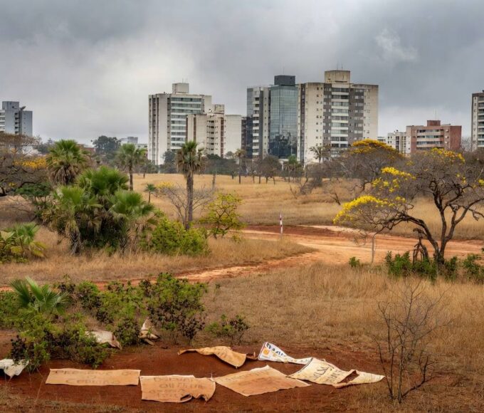 Reserva biológica no Guará ameaçada por pacote de salvamento do BRB, com faixas de protesto e vegetação do Cerrado.