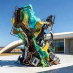 Instalação artística de sucata criticando sustentabilidade em exposição em Brasília.