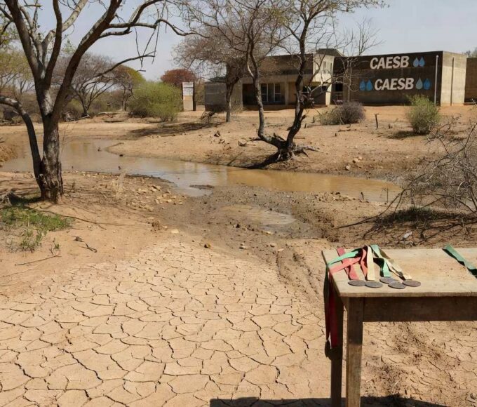 Nascente seca no DF contrastando com banner do Dia da Água, destacando perda ambiental.