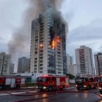 Incêndio em prédio residencial de Águas Claras com fumaça e caminhões de bombeiros no local.