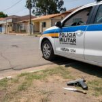 Viatura da PMDF em rua de Vicente Pires com simulacro de arma e faca no chão, cena de detenção.