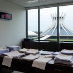 Mesa com documentos financeiros e calendário de prazo expirado em escritório bancário em Brasília, representando perda de prazo do BRB para balanço.