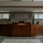 Sala de tribunal vazia no Distrito Federal, com símbolos de justiça representando julgamento de chacina em Planaltina.