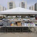 Tenda de acolhimento e assistência social do GDF em praça de Águas Claras, com suprimentos para população de rua.