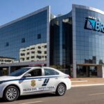 Viatura da Polícia Civil em frente ao prédio do Banco de Brasília, representando operação contra fraudes.