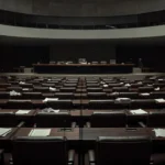 Plenário vazio da CLDF com documentos acumulados, simbolizando baixa produtividade dos deputados