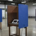 Cabine de votação vazia em seção eleitoral no DF representando proibição de celulares